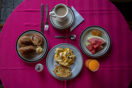 丰盛的早餐。一杯咖啡水果果酱炒鸡蛋肉饼面包和橙汁。摄影