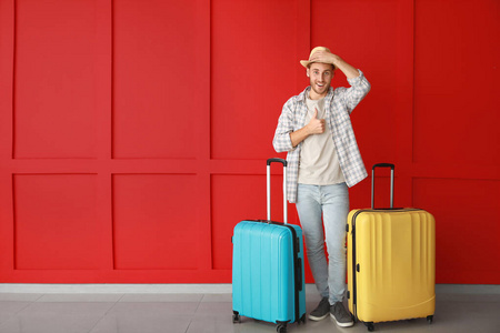 彩色背景行李的年轻男性游客