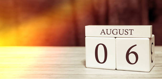 日历提醒事件概念。8月6日，阳光下，有数字和月份的木块。
