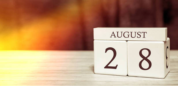 日历提醒事件概念。8月28日阳光下的数字和月份的木块。