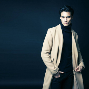 帅气的亚洲时尚男人在工作室里摆出黑色背景，现代人的生活方式理念