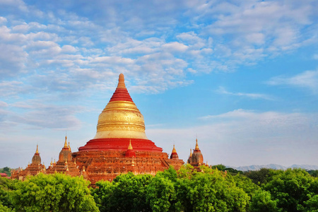 缅甸老巴甘，寺庙上方的蓝天被绿色植被包围。
