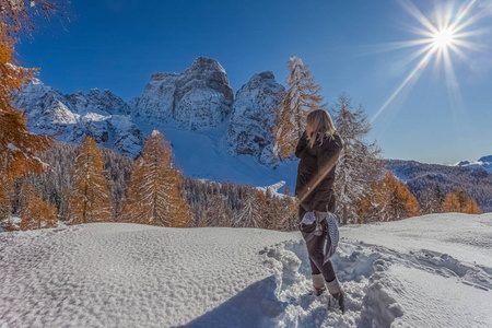 Blonde woman looking at a Dolomite mountain on a beautiful sunny