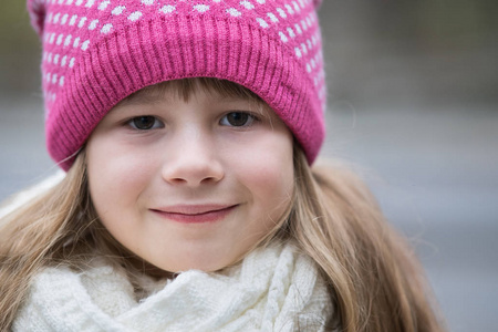 漂亮的小女孩穿着温暖的针织冬装在户外。