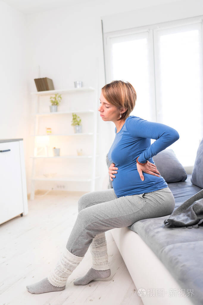 怀孕累得筋疲力尽的孕妇胃部问题和背部疼痛