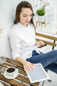 一个穿着白衬衫和牛仔裤的女人坐在咖啡馆里喝咖啡。女上班族在午休时间打电话。在一个餐馆的经理会议上