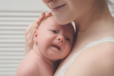 母亲怀里抱着一个金发的新生婴儿，一瞬间的柔情。特写