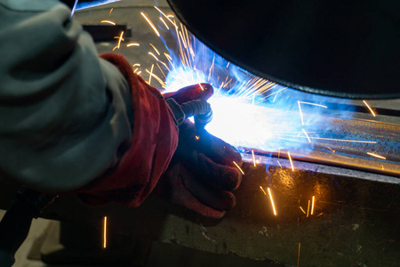 焊接工人在工厂进行生产操作。