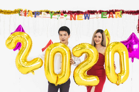 年轻夫妇一起庆祝新年，手持2020年气球