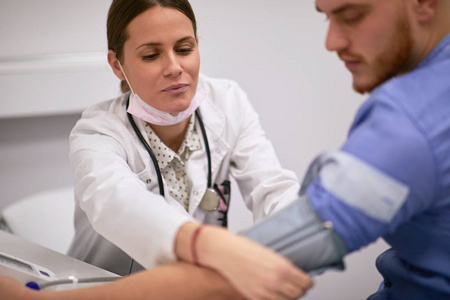 Female doctor measuring blood pressure 