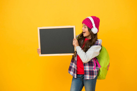 创意学校。快乐的孩子拿着学校的黑板。小女孩回到学校。小学生黄色背景。音乐课。学校和教育。永不停止学习，复制空间