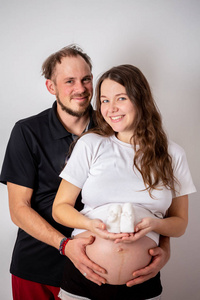 美丽的孕妇和她英俊的丈夫拥抱着肚子的裁剪图像