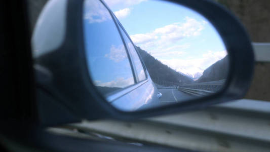 车辆行驶时后视镜反射雪山图片