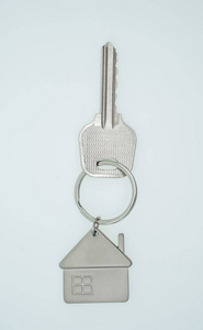 白色背景上带有房子标志和钥匙的钥匙链，真实的es