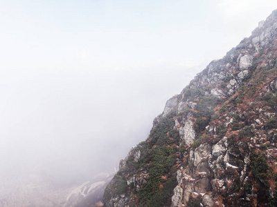 雾背景下植被稀少的山岩质边坡图片
