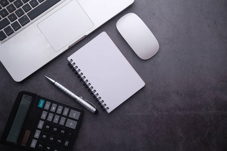 top view of laptop, calculator, pen and mouse on table 