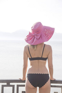 海边一个穿着泳衣戴着帽子的女孩。