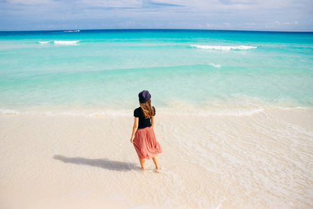 girl in a hat on a background of the ocean. Beautiful girl looks