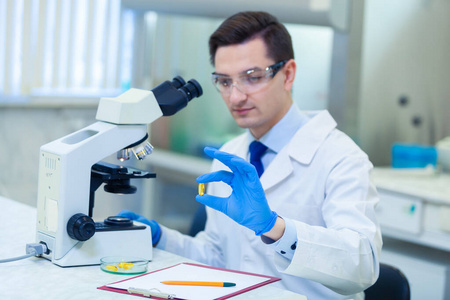 科学家在医学实验室里用显微镜和实验室设备研究欧米茄3脂肪酸的特性和益处