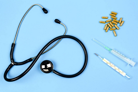 Stethoscope, syringe, mercury thermometer, pills, capsules with 