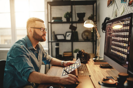 young man is a freelance photographer working on  computer 