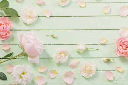 pink and white roses on green wooden background 
