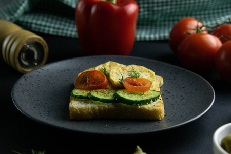 美味的三明治与土豆，黄瓜和西红柿在灰色盘子特写。