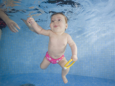 带着玩具的小宝宝在水下游泳
