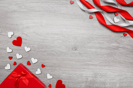 情人节背景。木制背景上的手工心形和红色礼品盒。