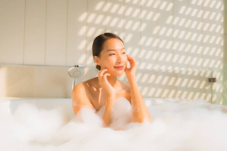 图为年轻的亚洲女人放松在浴缸里洗澡