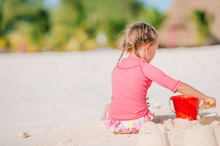 热带白色沙滩上的小女孩在造沙城堡