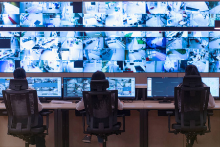 Security guard monitoring modern CCTV cameras in a surveillance 