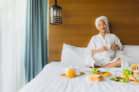 在床上画一位年轻的亚洲女人，卧室里有早餐