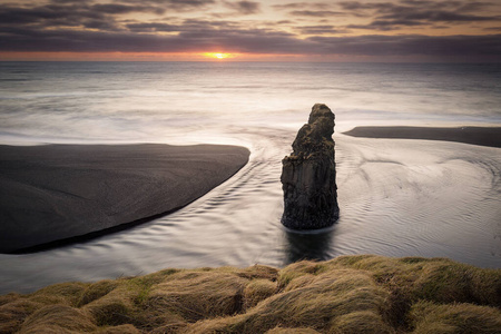 冰岛黑沙滩上的迪尔霍雷灯塔