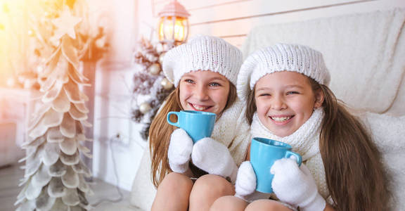 快乐的孩子们拿着杯子在圣诞背景下微笑