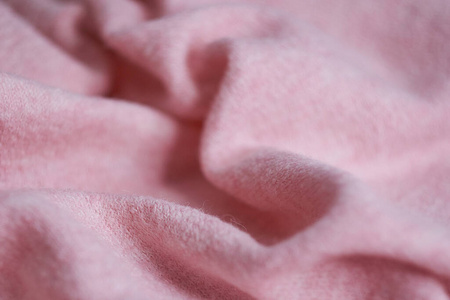 羊绒制成的柔软针织面料，有大褶皱，是衣服的一个细节。粉红色织物纹理