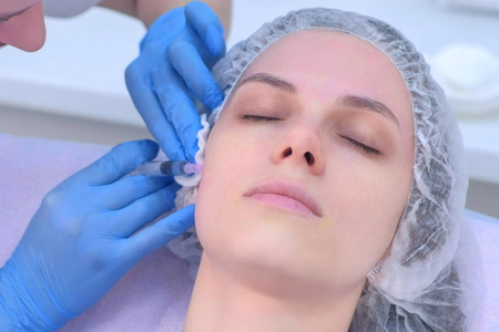 医生正在对女性面部皮肤进行中观疗法的多次注射。