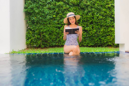 美丽的亚洲年轻女子围着游泳p看书