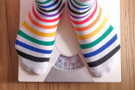 top view of women feet measuring weight on scale 