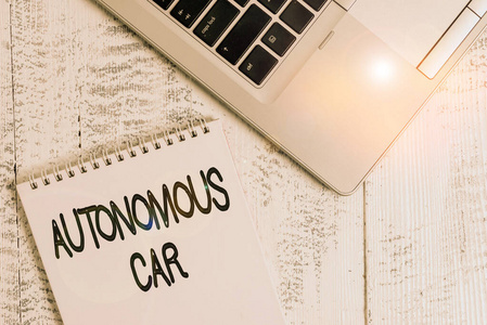 展示自动驾驶汽车的便条。商业照片展示的车辆，可以引导自己没有人的传导顶部时尚的金属笔记本电脑空白螺旋记事本躺在木桌上。