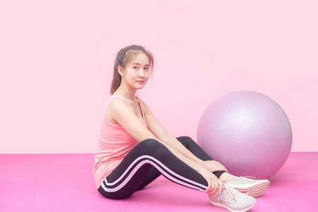 Cute asian woman smile with balls on pink background. 