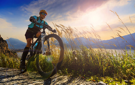 Cycling outdoor advenyure.Mountain biking woman at sunrise over 