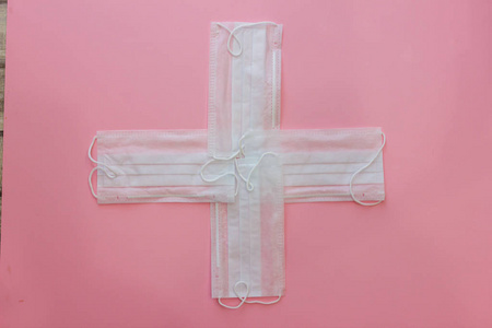 粉色背景的白色十字形医用口罩图片