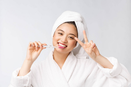 微笑女人刷牙的特写镜头。非常适合健康牙齿护理概念，隔离在白色背景上。亚洲的。