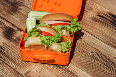 学校午餐盒，两个自制汉堡和新鲜黄瓜