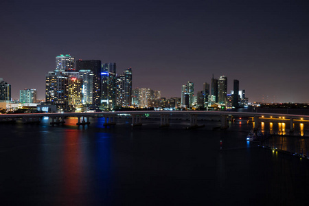 迈阿密城市天际线全景在黄昏与城市摩天大楼和桥在海上反射