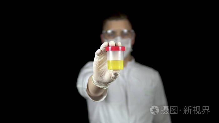 尿检库特写镜头男医生拿出一罐尿液对着镜头背景是黑色的