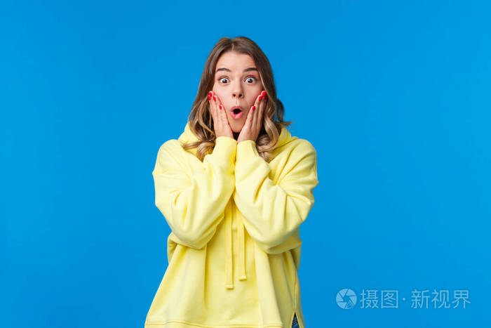 从惊讶的触摸脸颊盯着不相信和惊讶,听到奇妙的消息,蓝色的背景