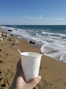 男人手拿着一杯咖啡对着大海图片