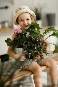 小女孩把室内的花放进花盆里图片